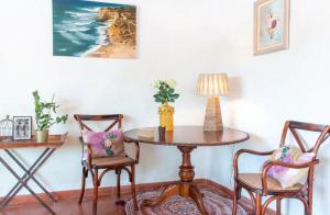 mesa con 2 sillas y mesa con lámpara en Akivillas Ericeira Charm, en Santo Isidoro