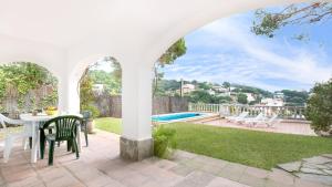 リョレート・デ・マルにあるVilla Montecarloのパティオ(テーブル、椅子付)、プールが備わります。