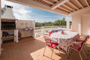 a patio with a table and chairs and a pool at Casa da Alcaria by Portucasa in Altura