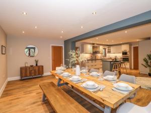 a dining room and kitchen with a wooden table and chairs at Crooklands Cottage in Milnthorpe