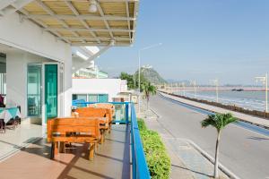 a balcony with chairs and a view of the ocean at Hadthong Hotel in Prachuap Khiri Khan