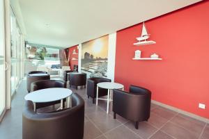 a restaurant with tables and chairs and a red wall at Salmanha Residence in Figueira da Foz