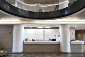 una escalera circular en el vestíbulo de un hospital con columnas en Hotel Alda Sada Marina, en Sada