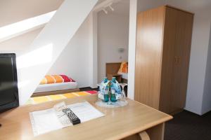 Habitación con mesa de madera, 1 cama y 1 dormitorio en Hotel Albena - garni Hotel, en Fürstenwalde