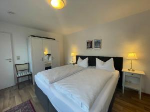 - une chambre avec un grand lit blanc et une chaise dans l'établissement Apartment mit Terrasse No1, à Quedlinbourg