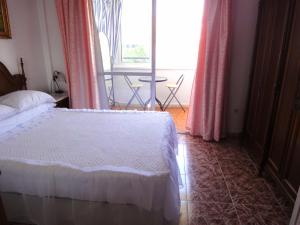 sypialnia z łóżkiem, oknem i stołem w obiekcie Costamar, Primera linea de playa, 3 dormitorios, 2 baños, vistas al mar, Internet Wifi y Garaje, Ideal parejas y familias w mieście Benalmádena