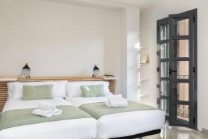 un letto bianco con asciugamani in una stanza di Flateli Plaça Catalunya 10 a Girona