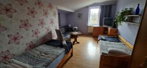 - un salon avec 2 lits et une télévision dans l'établissement Noclegi u Lili, à Człuchów
