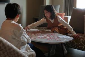 a boy and a girl playing a game on a table at FAV HOTEL ISE in Ise