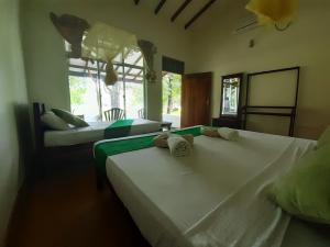una camera da letto con due letti e una finestra di Banana Rest Sigiriya a Sigiriya