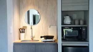 una cucina con lavandino, forno a microonde e specchio di fav ISE a Ise