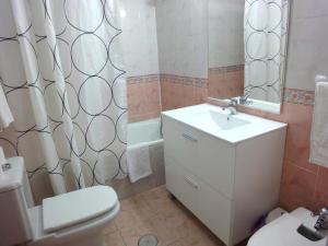 łazienka z umywalką, toaletą i lustrem w obiekcie Costamar, Primera linea de playa, 3 dormitorios, 2 baños, vistas al mar, Internet Wifi y Garaje, Ideal parejas y familias w mieście Benalmádena +14 zdjęć