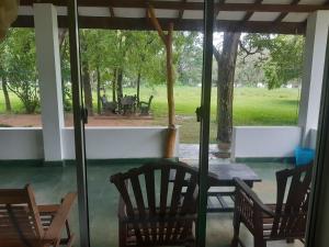 una veranda riparata con tavolo e sedie di Banana Rest Sigiriya a Sigiriya