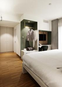 a hotel room with a large bed and a desk at Astoria Resort in Riva del Garda