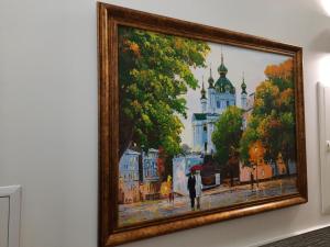 a painting of a woman with an umbrella on a street at Summit Apart Hotel in Kyiv