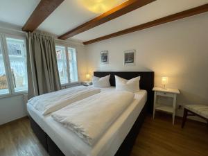 sypialnia z dużym białym łóżkiem i 2 oknami w obiekcie Apartment mit Terrasse No3 w mieście Quedlinburg