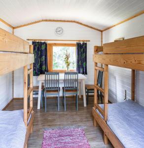 una habitación con mesa y sillas en una cabaña en Cafe Alppila, en Iniö