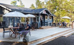 a wooden deck with people sitting at a table at Cafe Alppila in Iniö