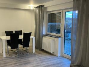 a dining room with a table and chairs and a window at Ferienwohnung am Wald in Haiterbach +16 photos