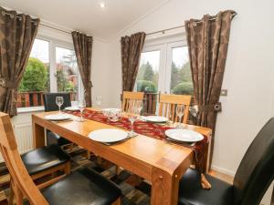 uma sala de jantar com uma mesa de madeira e cadeiras em 3 The Fairway em Cottingham