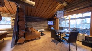 una sala da pranzo con tavolo e sedie in una cabina di Arcticvillas Tunturituikku a Kemijärvi
