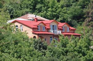 una casa en la cima de una colina con árboles en Zandarashvili Guest House, en Signagi