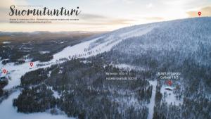 a view of a snow covered mountain with trees at Arcticvillas Tunturituikku in Kemijärvi