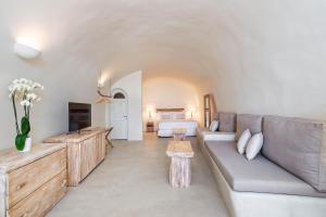 a living room with a couch and a bed at The Ivory Suite in Santorini in Oia