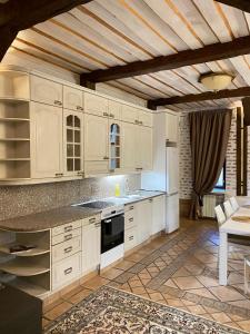uma cozinha com armários brancos e um frigorífico branco em Атмосферные апартаменты с сауной и видом на парк em Vyborg
