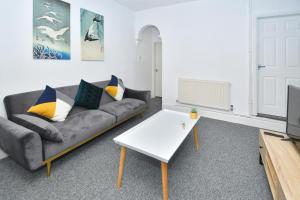 a living room with a couch and a table at The Yellow Door by Avenew Management Serviced Accommodation in Stoke on Trent