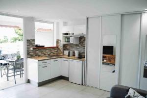 Η κουζίνα ή μικρή κουζίνα στο Les Alizés Bleus - Cosy appartement avec piscine