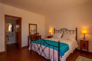 una camera con un letto, due lampade e un lavandino di O Monte da Estrada a Zambujeira do Mar