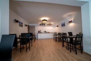 a dining room with tables and chairs and a kitchen at VIPABO Holiday SolneSPA in Niechorze