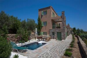 uma villa com piscina em frente a uma casa em Villa Carmina em Egina