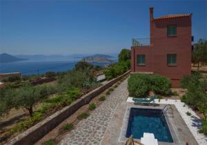 a house with a swimming pool next to a building at Villa Carmina in Aegina Town