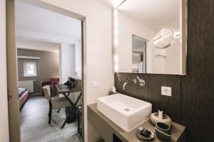 a bathroom with a sink and a mirror at Boutique Hotel Pfauen in Schorndorf