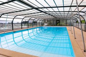 una piscina cubierta con techo de cristal en Village Club Les Cîmes du Léman-Neaclub, en Habère-Poche