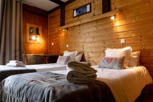 twee bedden in een kamer met houten wanden bij Village Club Les Cîmes du Léman-Neaclub in Habère-Poche +24 foto's