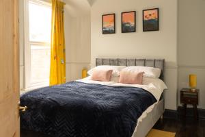 Langleigh Villa في إلفراكومب: غرفة نوم مع سرير مع وسادتين ورديتين عليه