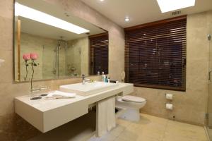 a bathroom with a sink and a toilet and a mirror at InterContinental Santiago, an IHG Hotel in Santiago