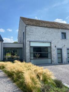 een bakstenen huis met grote ramen aan de zijkant bij Gîte de la Chapelle in Samart