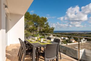 einen Tisch und Stühle auf einem Balkon mit Meerblick in der Unterkunft Villa Gill in Punta Grossa