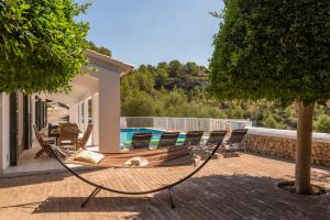 a hammock on a house with a swimming pool at Villa Es Torrent Verd in Alaior