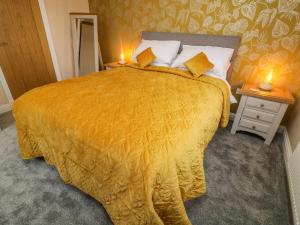 a bedroom with a large bed with a yellow blanket at Market Lounge in Clitheroe