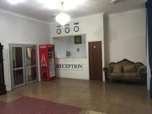 una sala de estar con una máquina de coca cola y un sofá en Гостиница Райхан, en Atyraū