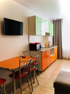 a kitchen with a table and chairs and a microwave at Guest House Bereg in Anapa