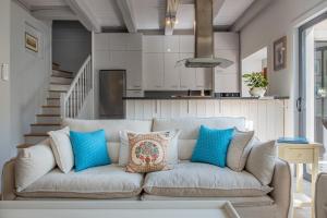 a living room with a couch with blue pillows at La Baronnie Villa & Spa in Saint-Martin-de-Ré