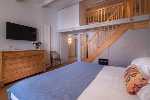 a bedroom with a large bed and a wooden staircase at La Baronnie Villa & Spa in Saint-Martin-de-Ré +24 photos