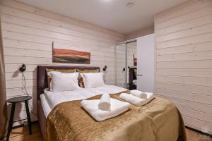 1 dormitorio con 1 cama grande y toallas. en Holiday In Lapland - SointuiLevi B68 sa1, en Levi