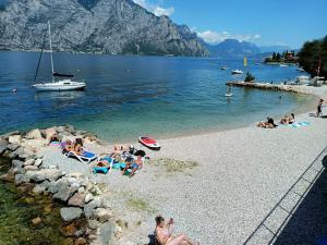 a group of people laying on a beach in the water at Hotel Al Molino in Malcesine